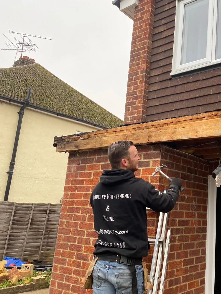 A roofer working on a porch canopy roof