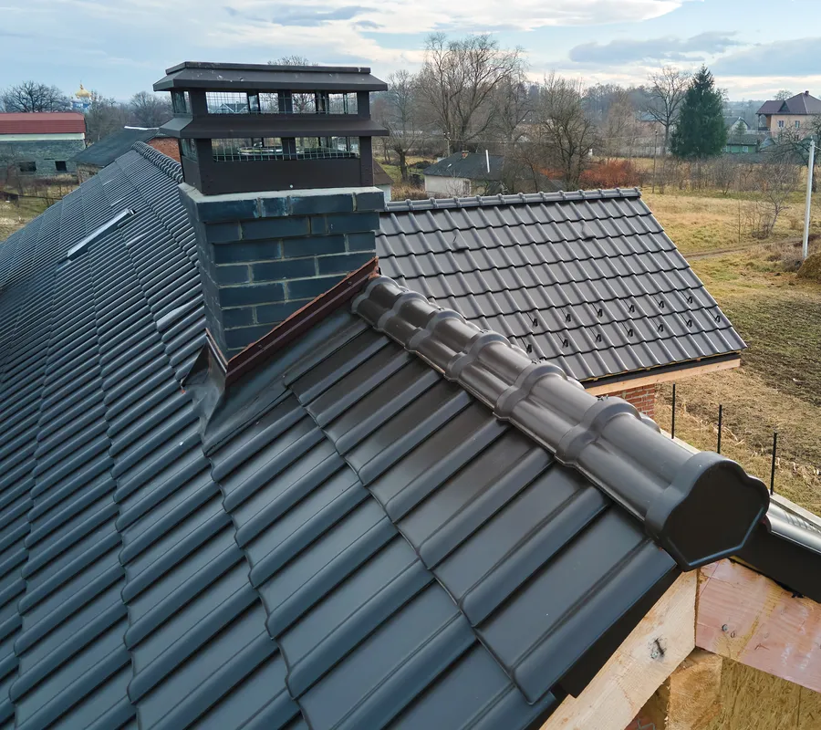 A chimney stack on a new tiled roof