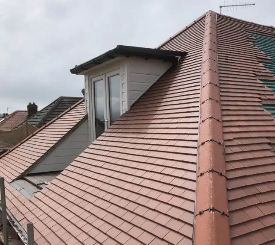 A tiled roof with a new ridge and dormer